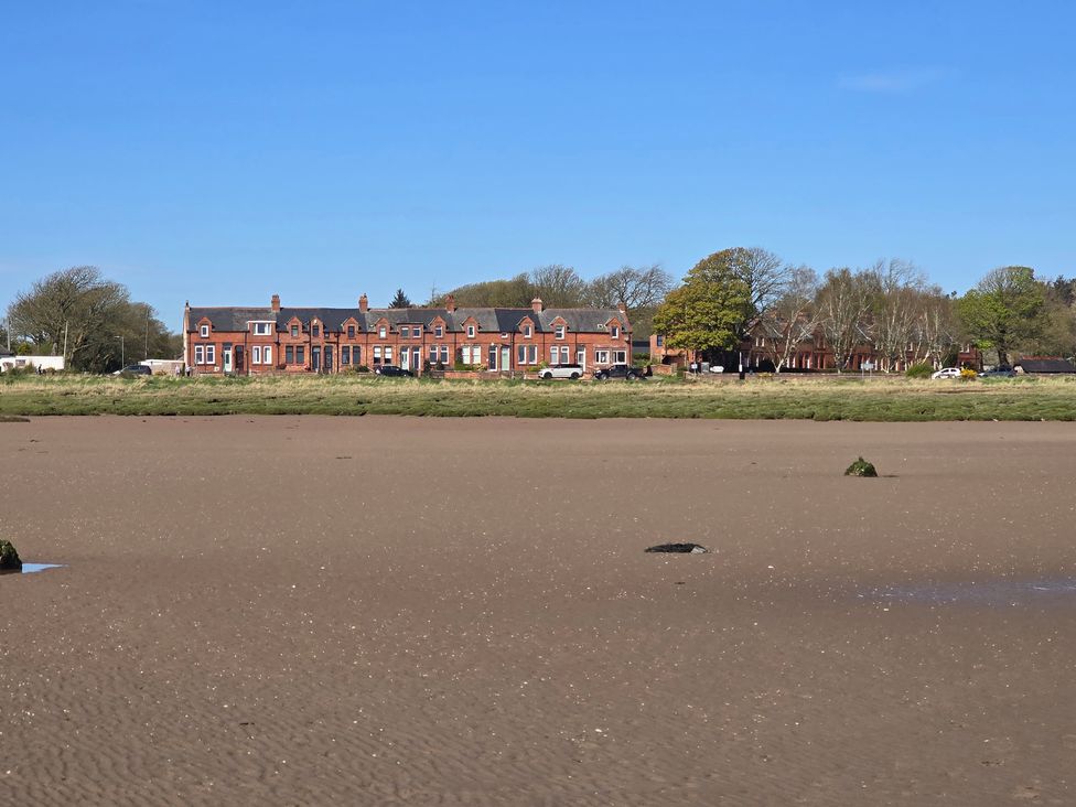 A view of houses and trees along the shore at Sandy Toes, Powfoot, Annan