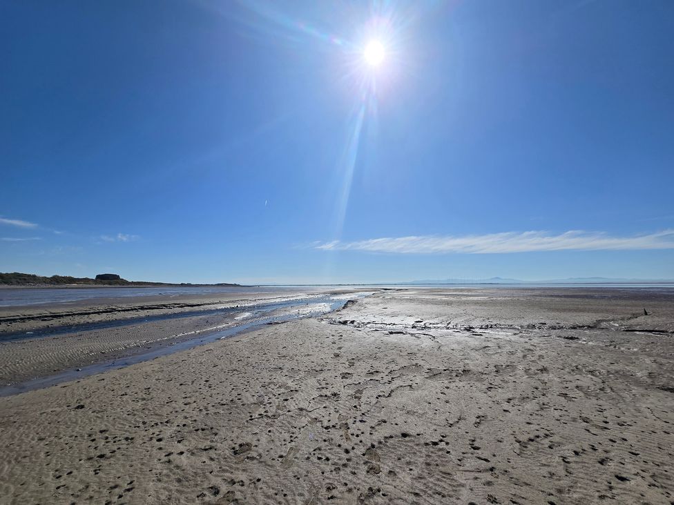 A beach scene with sand and water at Sandy Toes, Powfoot, Annan