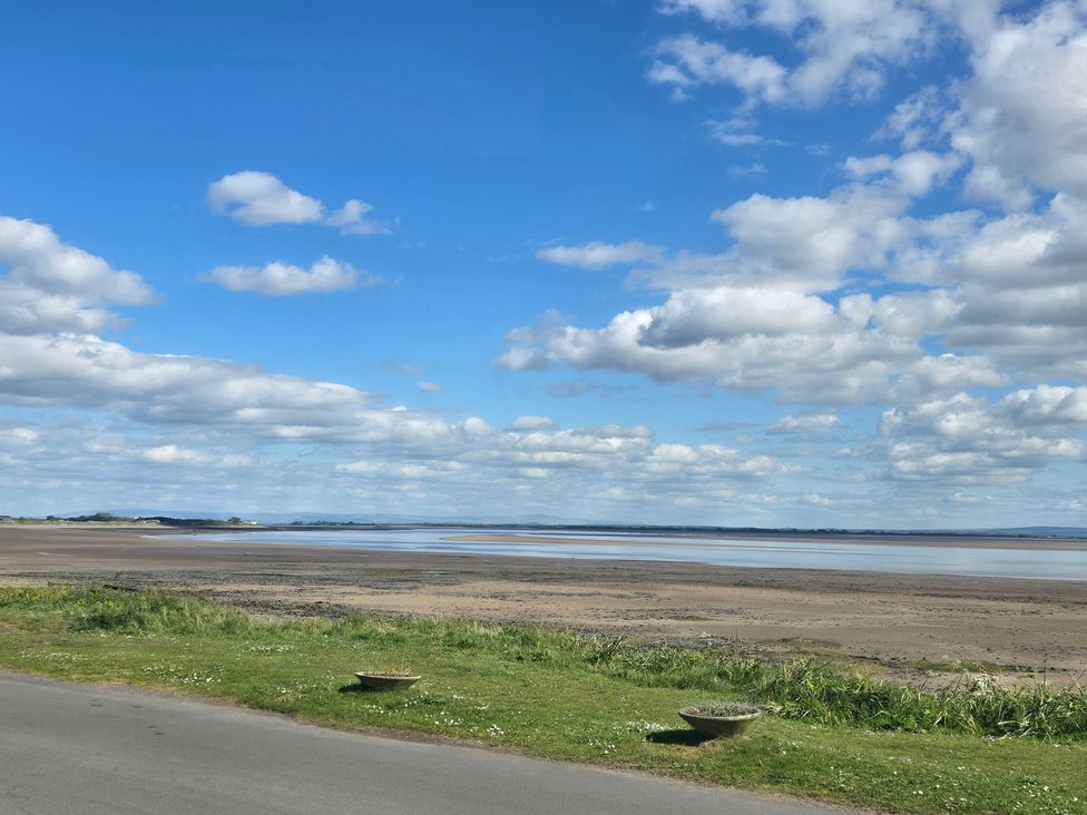 A view of a beach with sand and water at Sandy Toes, Powfoot, Annan