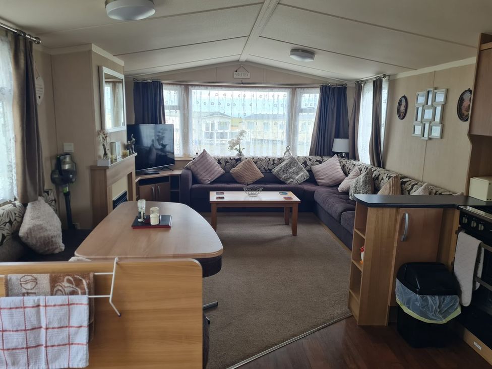 A living room with a sofa and television at Stoup cross caravan park in Whitby
