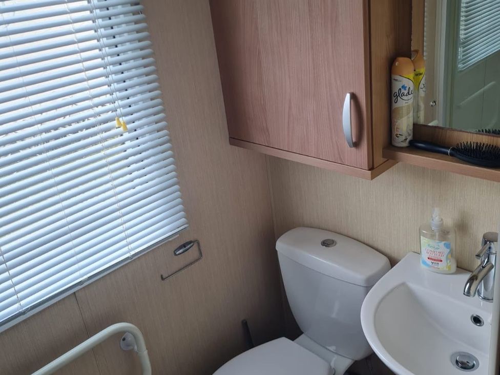 A bathroom with a toilet and sink at Stoup cross caravan park in Whitby