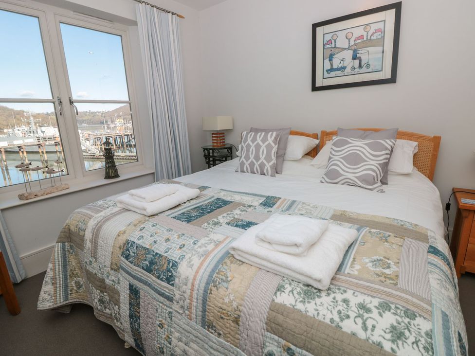 A bedroom with a bed and window overlooking the harbor at 33 Dart Marina in Dartmouth