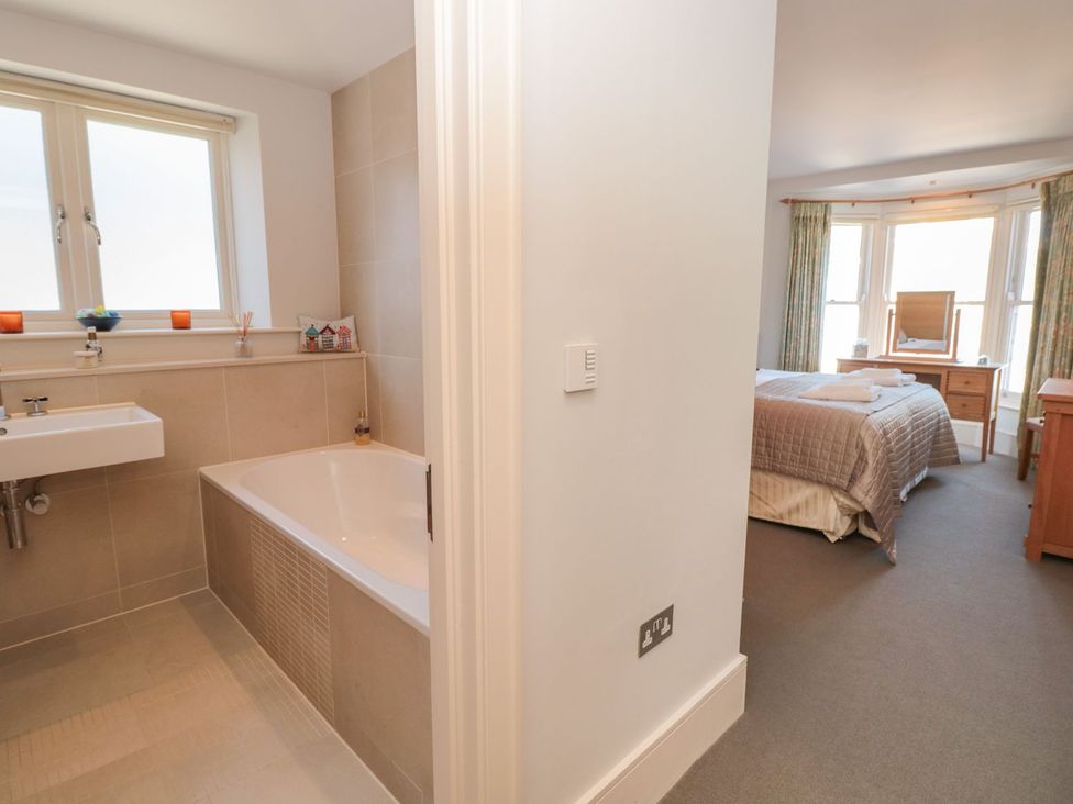 A bathroom with a bathtub and sink leading to a bedroom at 33 Dart Marina Dartmouth
