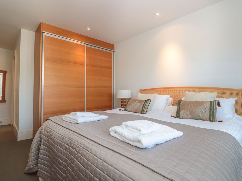 A bedroom with a bed and wardrobe at 33 Dart Marina in Dartmouth