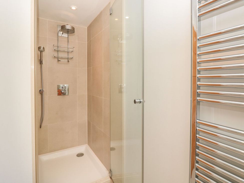 A shower area with tiled walls and a towel rail at 33 Dart Marina in Dartmouth