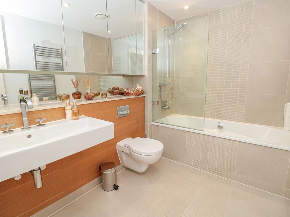 A bathroom with a sink, bath, and toilet at 33 Dart Marina in Dartmouth