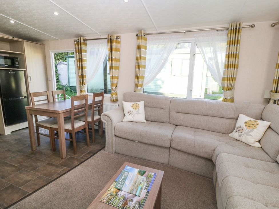 A living room with a sofa and dining area at Cox Tor in Tavistock