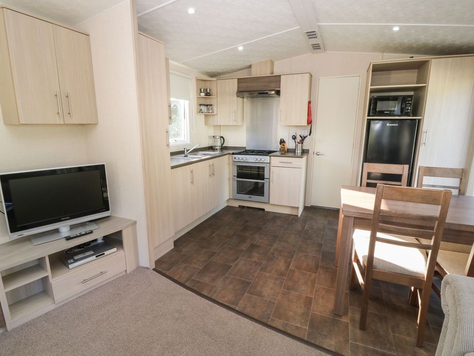 A kitchen with appliances and dining table at Cox Tor in Tavistock