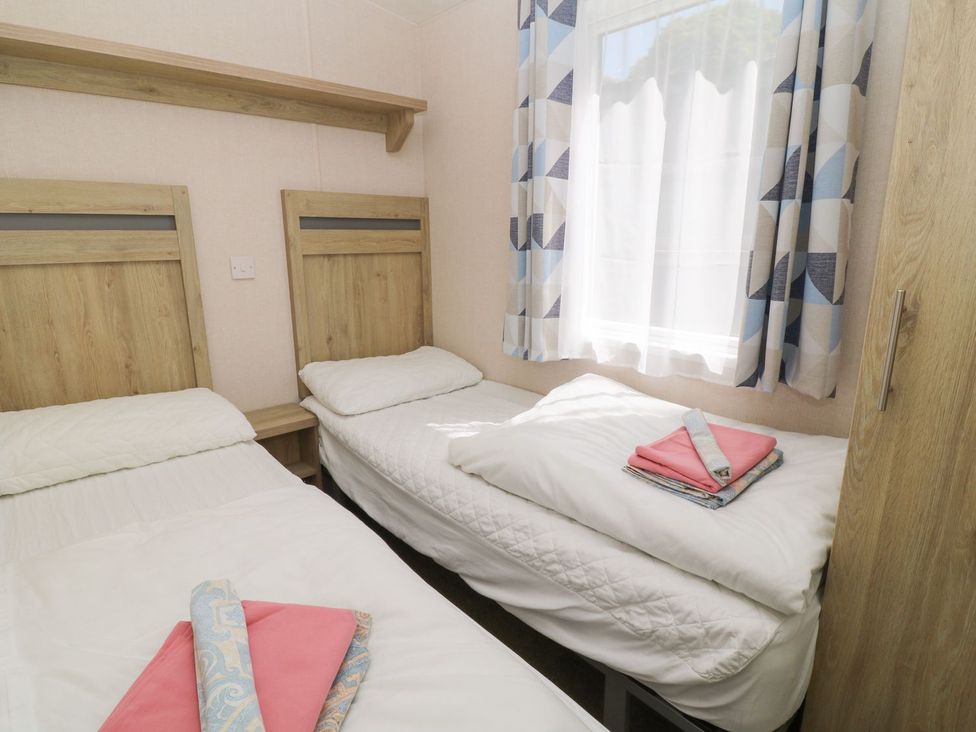 A bedroom with twin beds and shelves at Cox Tor Tavistock