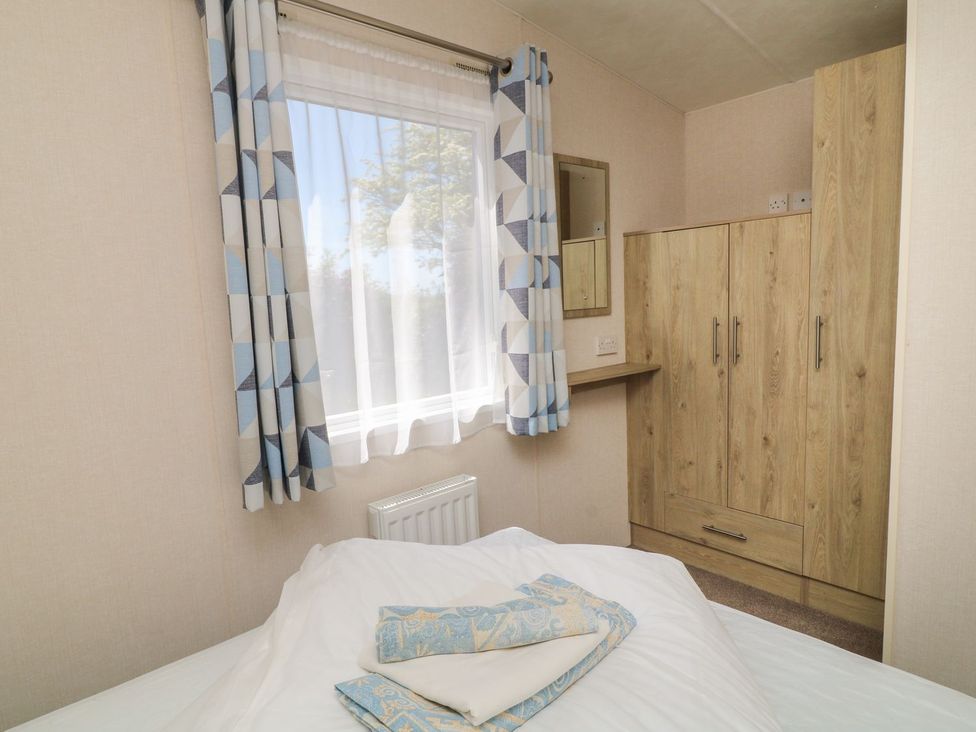 A bedroom with a bed and wardrobe at Cox Tor in Tavistock