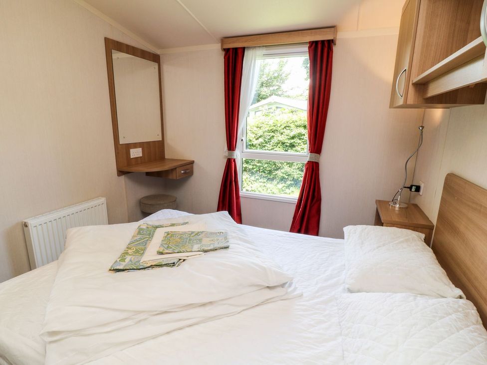 A bedroom with a bed and mirror at Brent Tor in Tavistock
