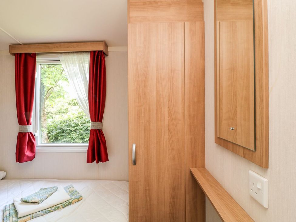 A bedroom with a window and wardrobe at Brent Tor in Tavistock