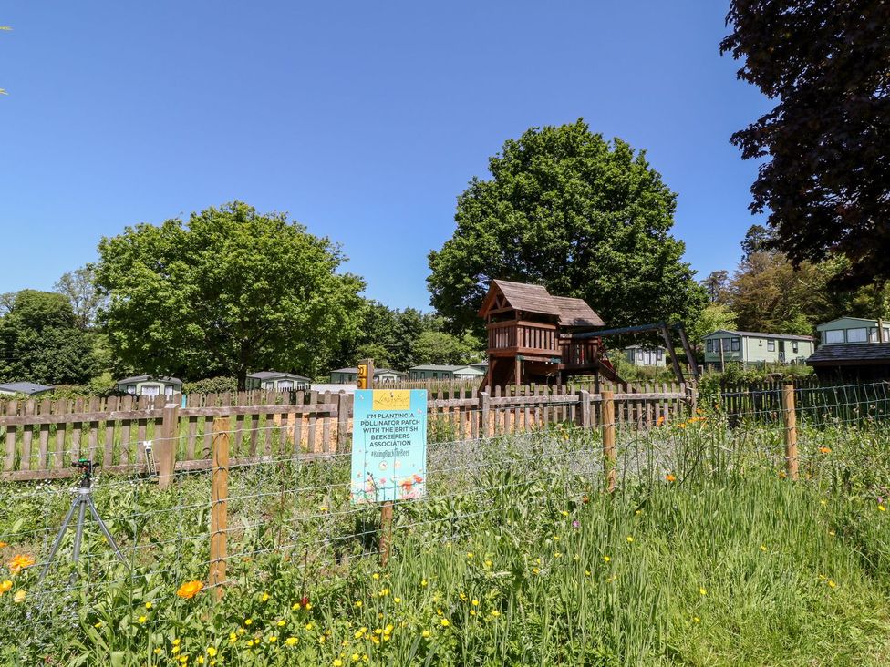 An outdoor area with a playground and caravans at Brent Tor Tavistock