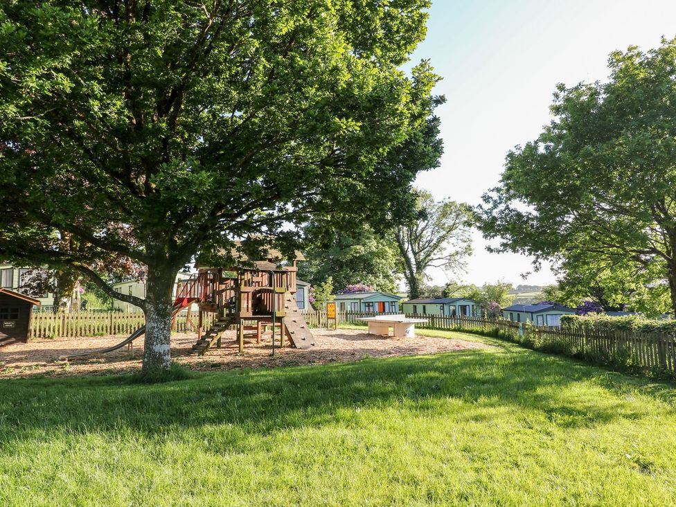 A playground with a structure and trees at Brent Tor in Tavistock