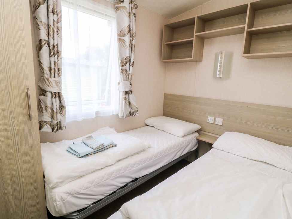 A bedroom with two beds and shelves at Great Mis Tour in Tavistock