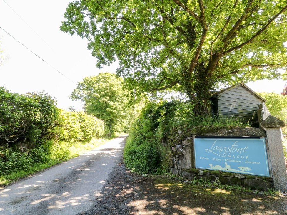 A pathway with trees and a sign at Langstone Manor in Tavistock