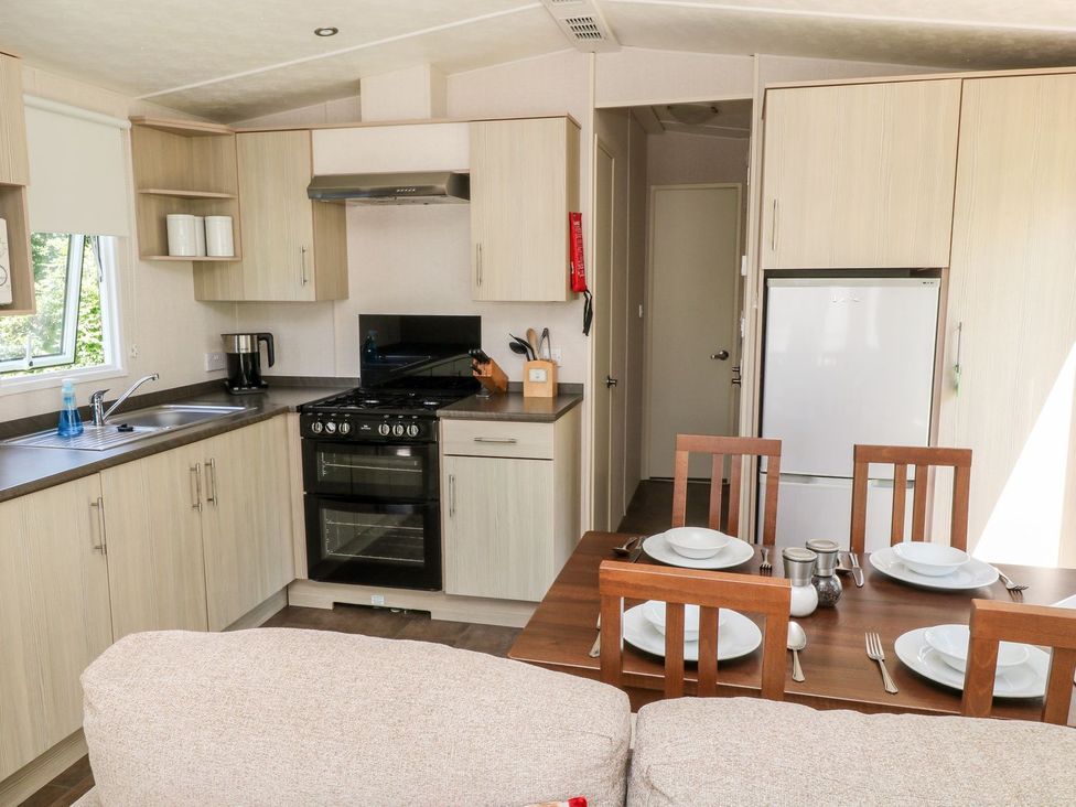 A kitchen with a dining table and appliances at Roos Tor in Tavistock