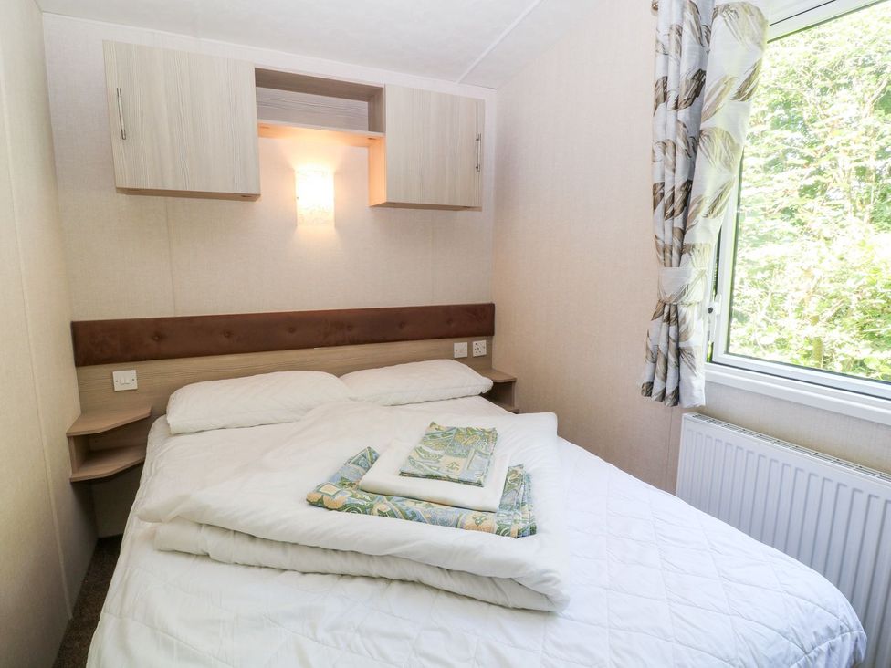 A bedroom with a bed and window at Roos Tor in Tavistock