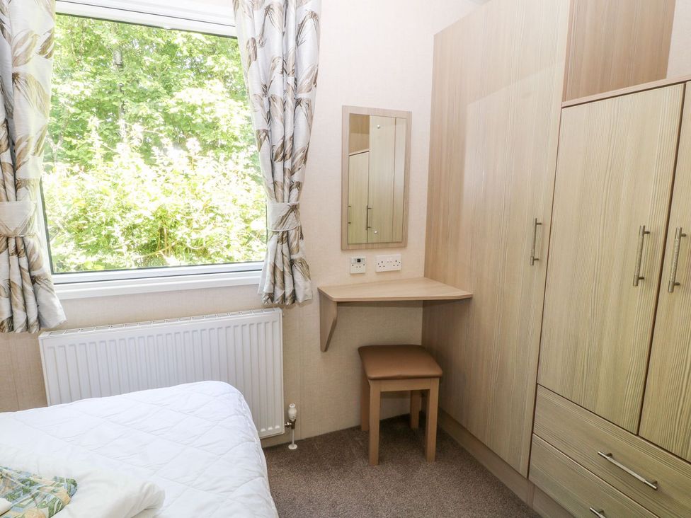 A bedroom with a desk and wardrobe at Roos Tor in Tavistock