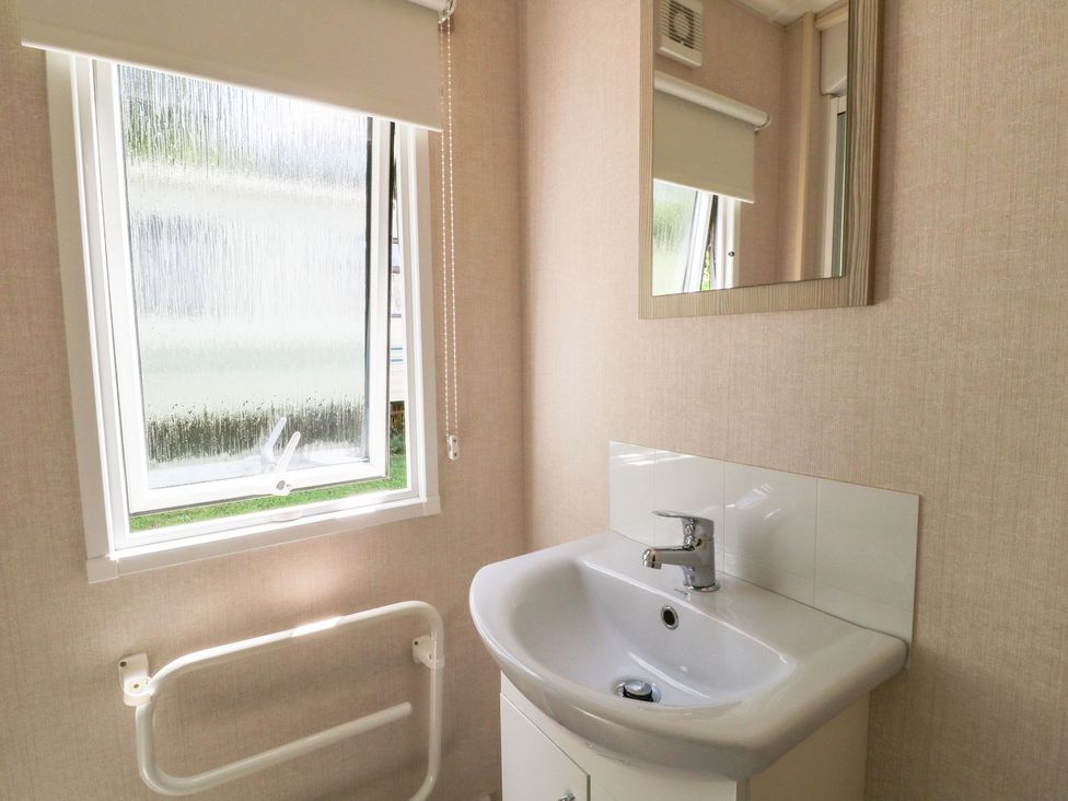 A bathroom with a sink and mirror at Roos Tor in Tavistock