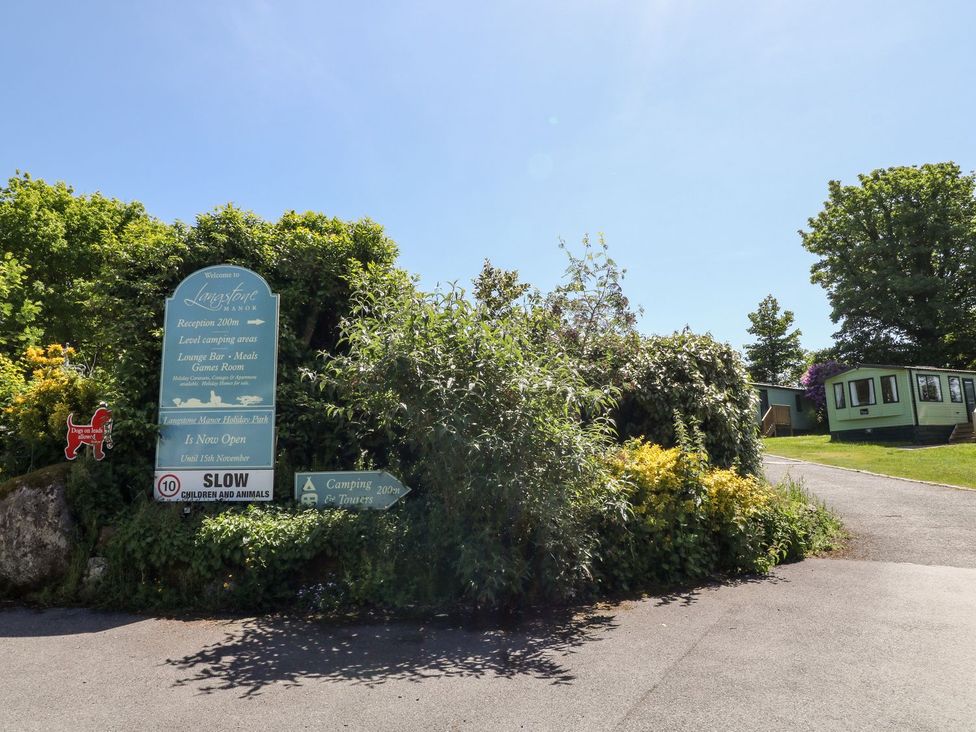 An outdoor area with a sign directing to reception and camping facilities at Langstone Manor in Tavistock