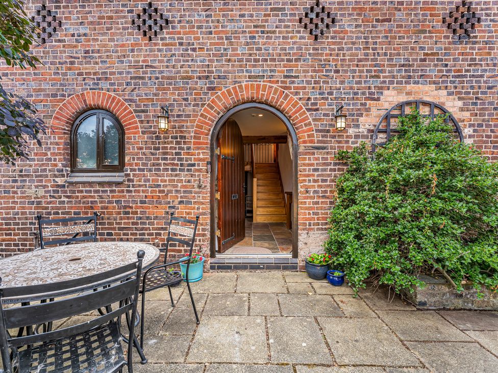 An outdoor entrance with a table and chairs at Oxhay Barn Newcastle