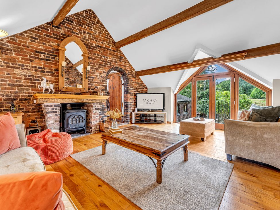 A living room with a fireplace and television at Oxhay Barn in Newcastle