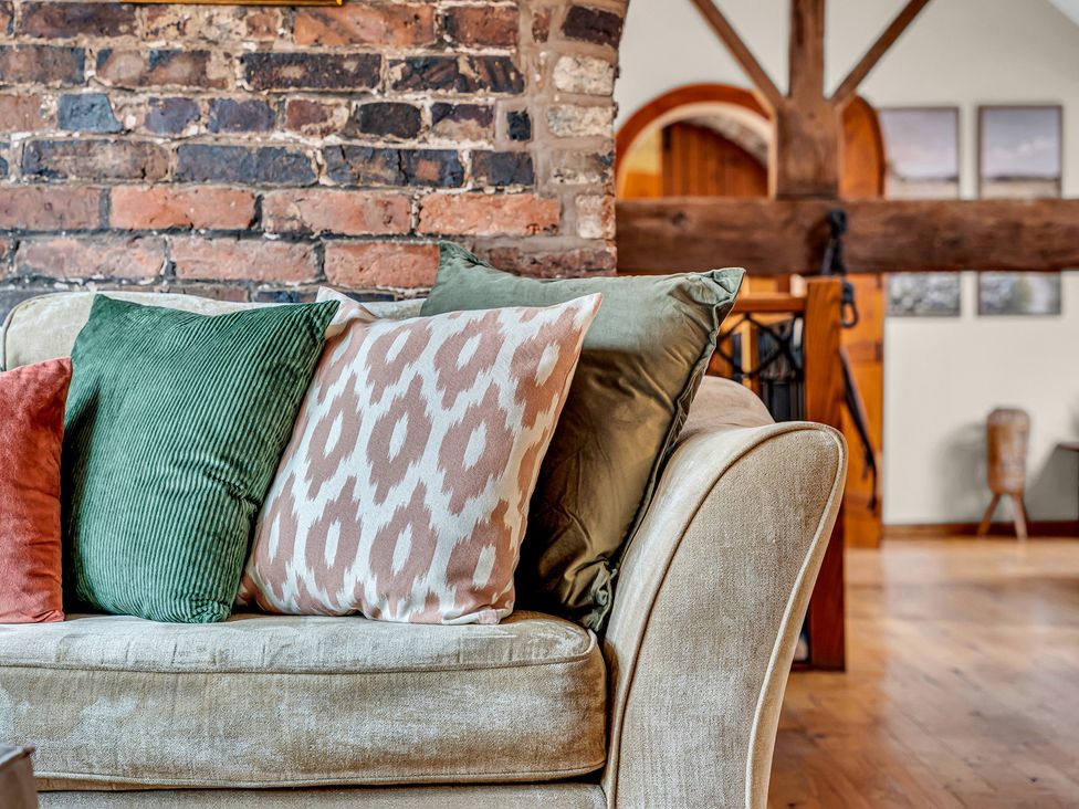 A living room with a sofa and cushions at Oxhay Barn Newcastle