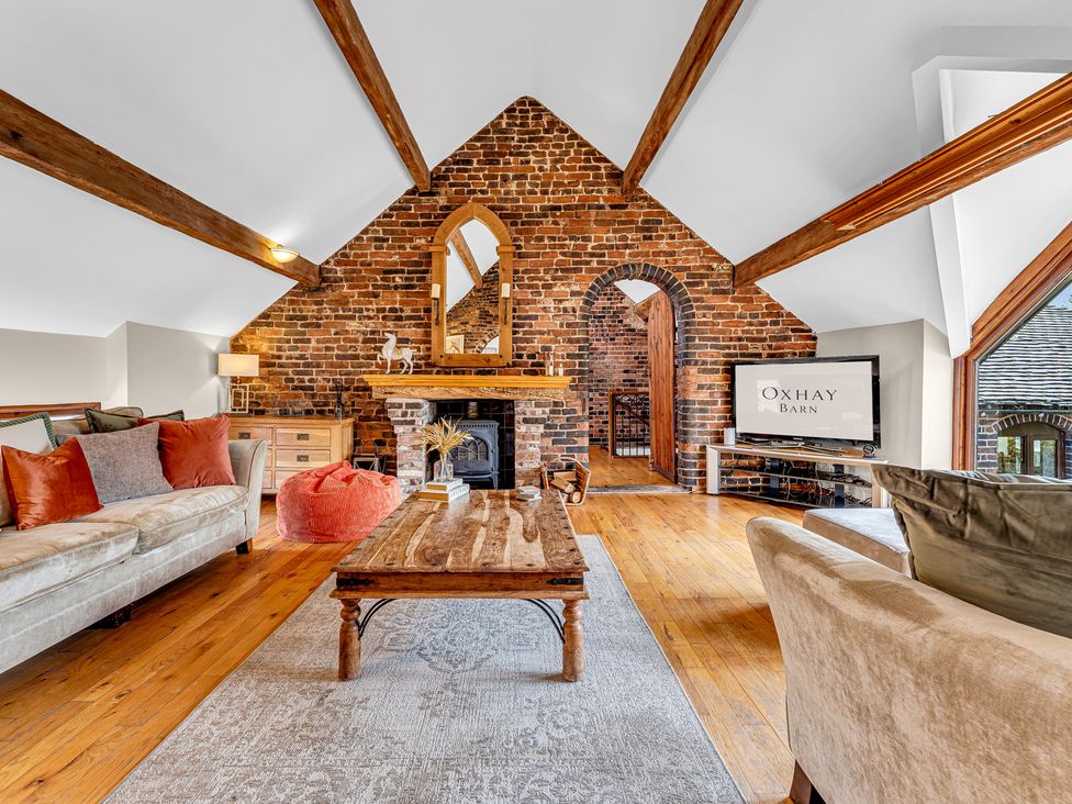 A living room with a coffee table and a fireplace at Oxhay Barn in Newcastle