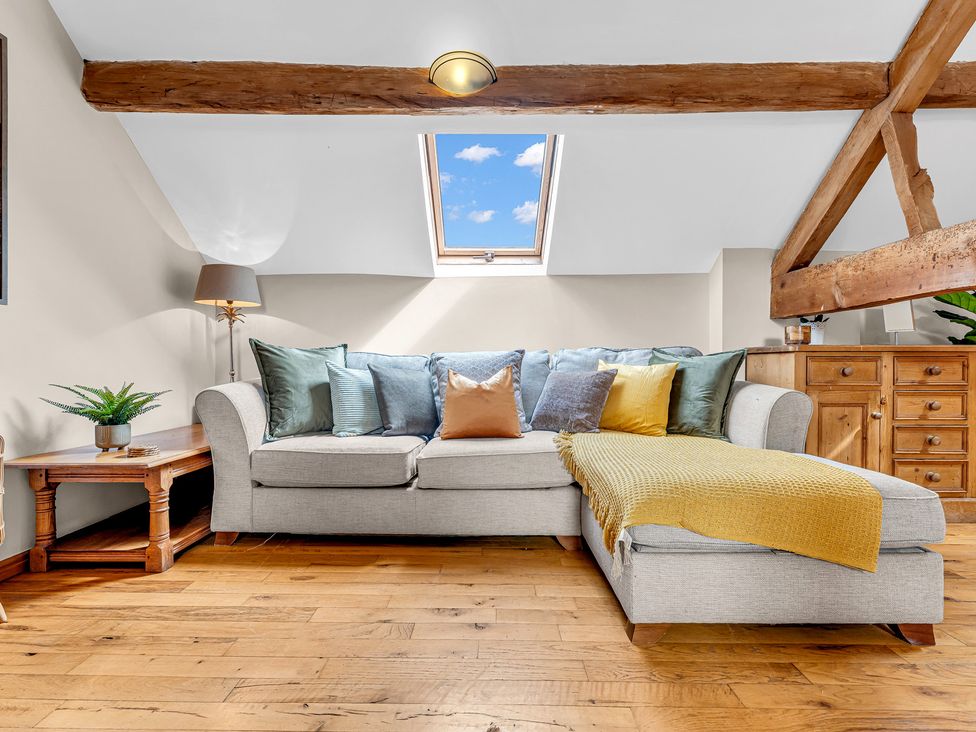 A living room with a sofa and cushions at Oxhay Barn Newcastle