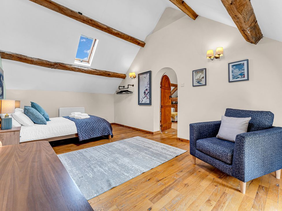 A bedroom with a bed and chair at Oxhay Barn Newcastle