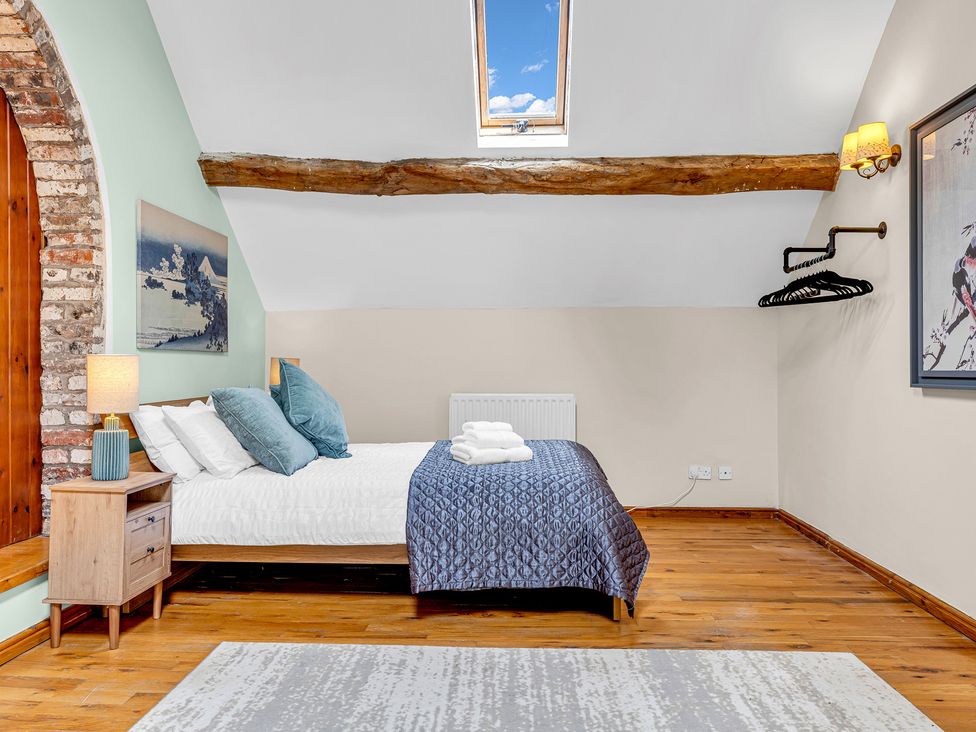 A bedroom with a bed and lamp at Oxhay Barn Newcastle