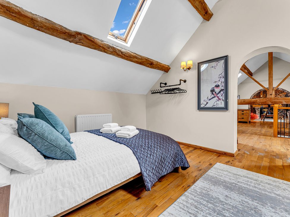 A bedroom with a bed and wall art at Oxhay Barn Newcastle