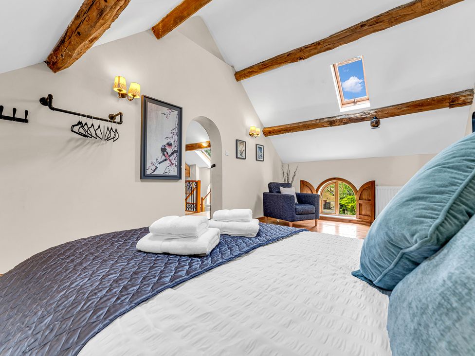A bedroom with a bed and chair at Oxhay Barn Newcastle