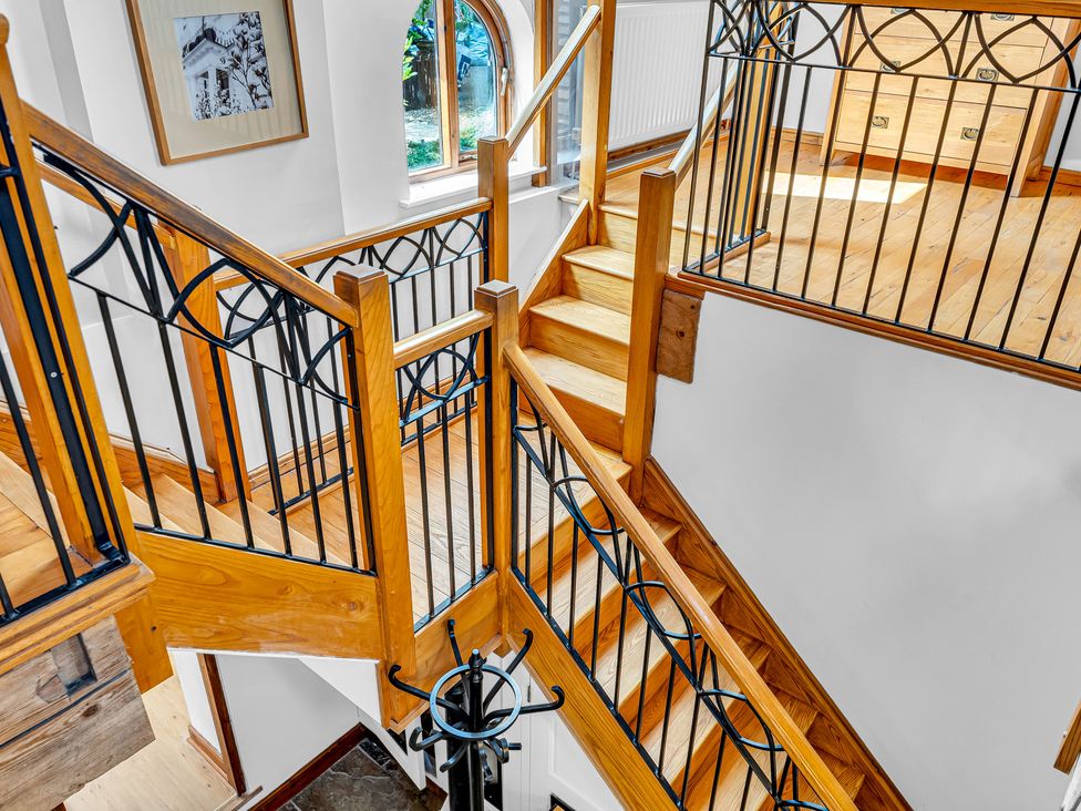 A staircase with wooden handrail at Oxhay Barn Newcastle