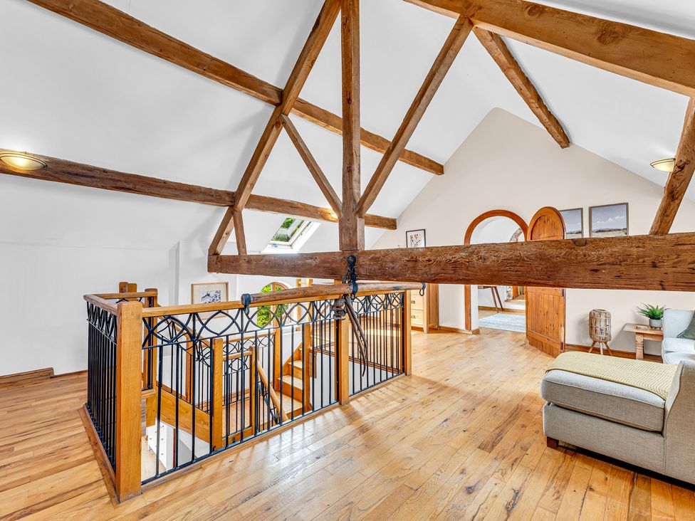 A landing area with wooden railing and stairs at Oxhay Barn Newcastle