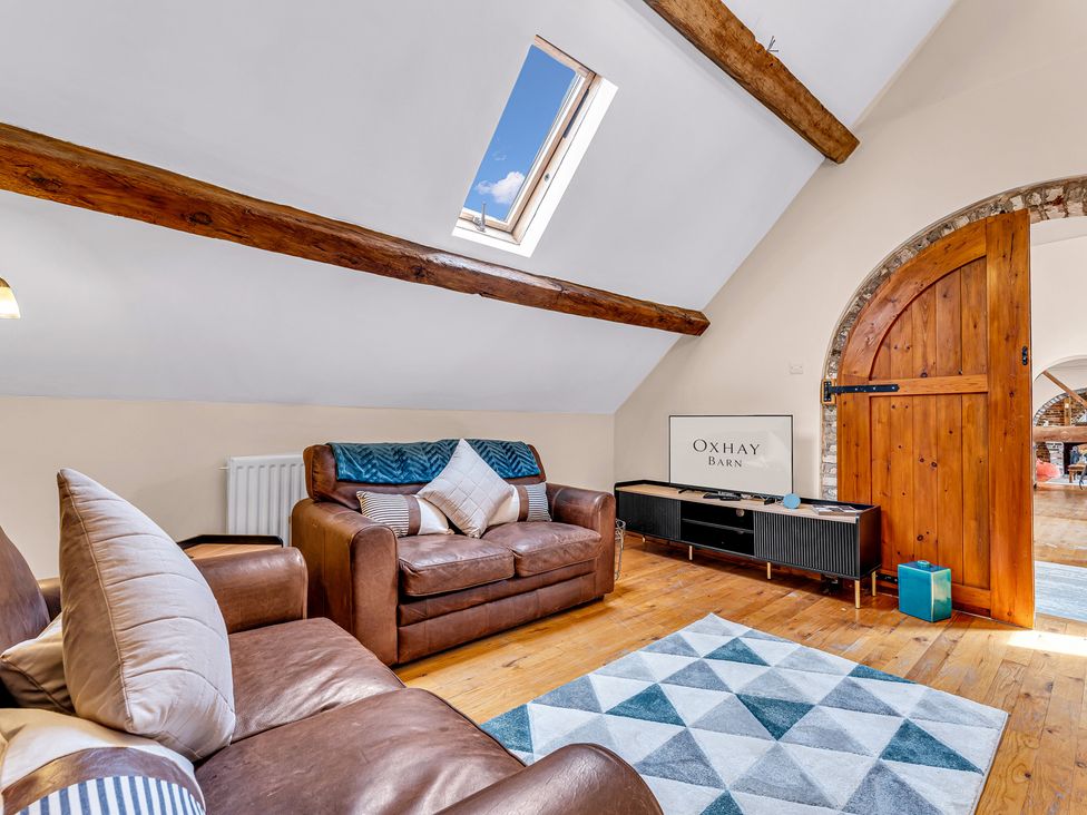 A living room with a sofa and TV at Oxhay Barn Newcastle
