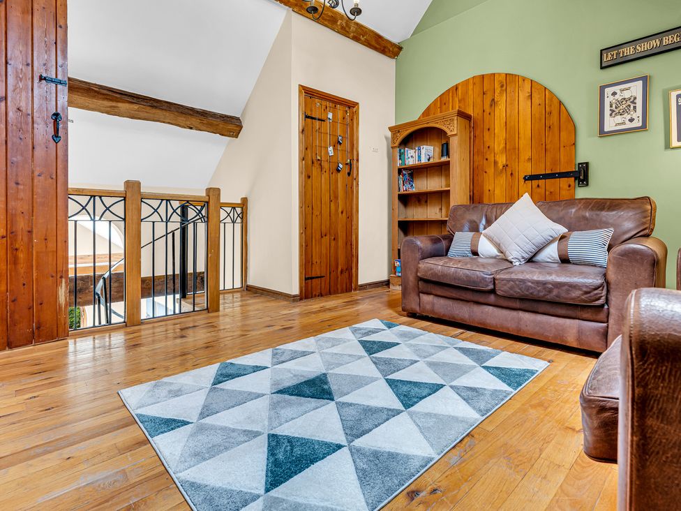A living room with a sofa and bookshelf at Oxhay Barn Newcastle