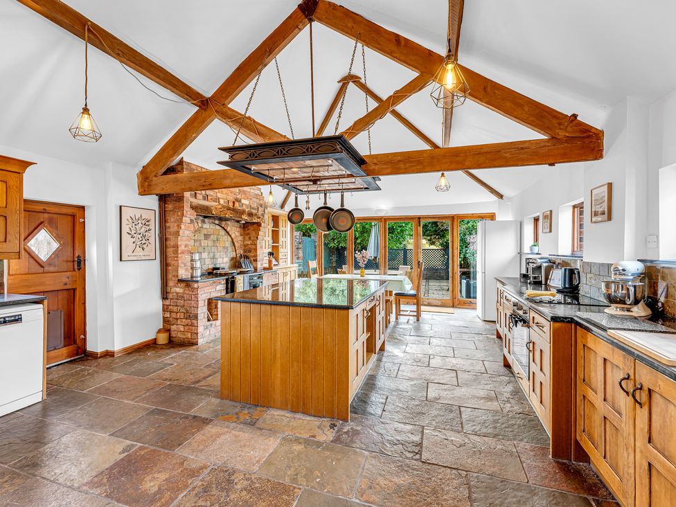 A kitchen with an island, cabinets, and appliances at Oxhay Barn Newcastle