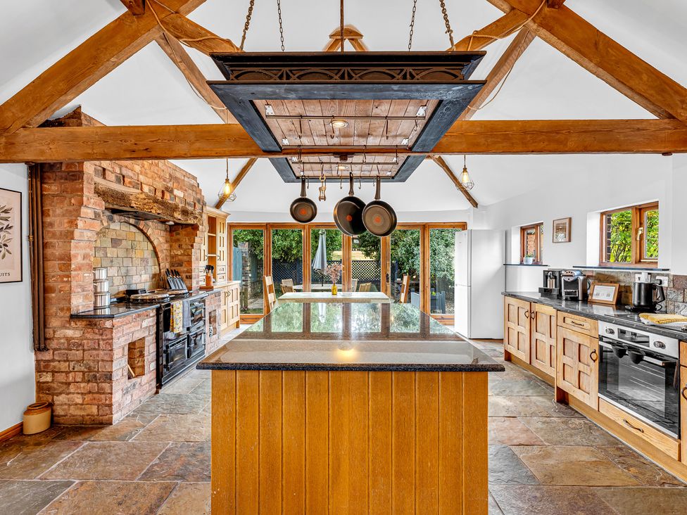 A kitchen with an island and cooking range at Oxhay Barn Newcastle