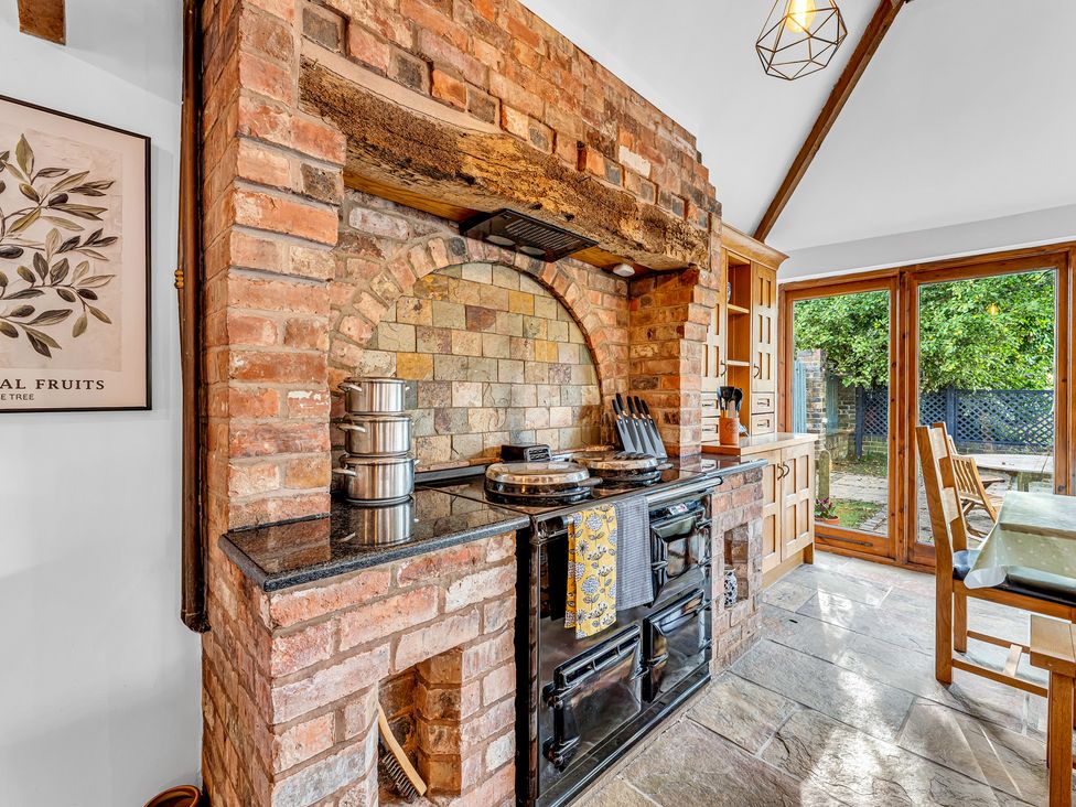 A kitchen with a stove and large windows at Oxhay Barn Newcastle