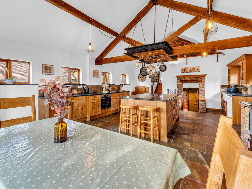 A kitchen with wooden cabinets and a dining table at Oxhay Barn in Newcastle