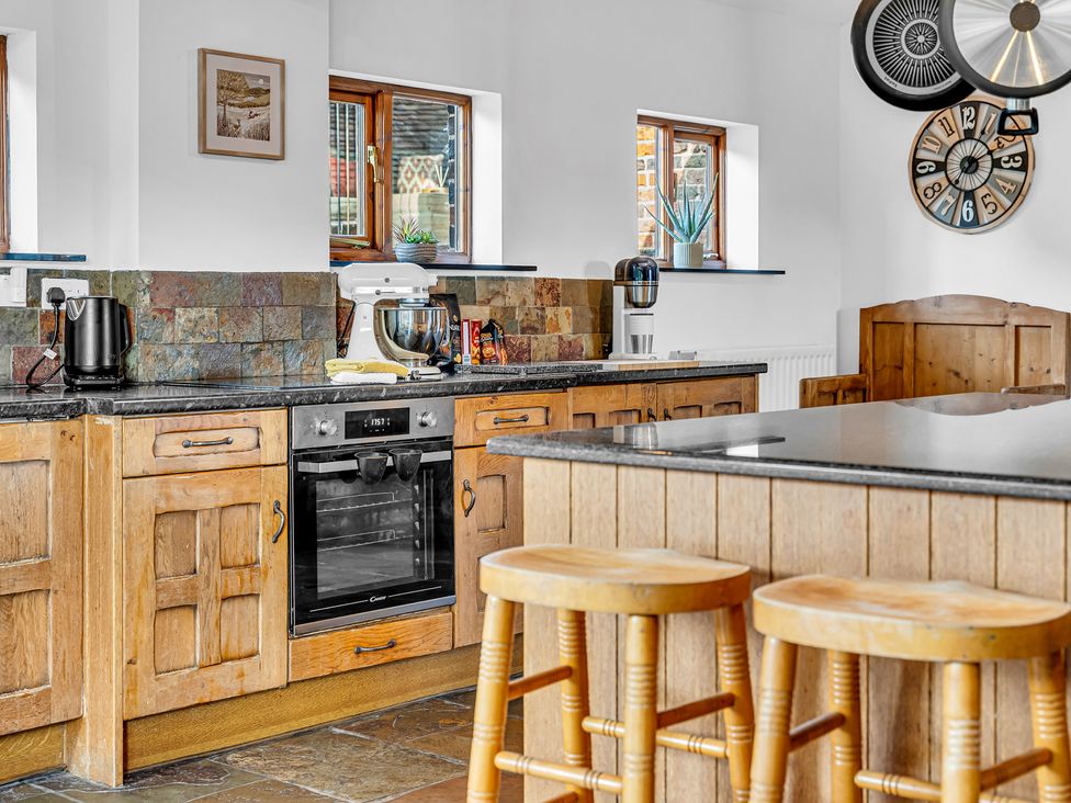 A kitchen with wooden cabinets and appliances at Oxhay Barn Newcastle