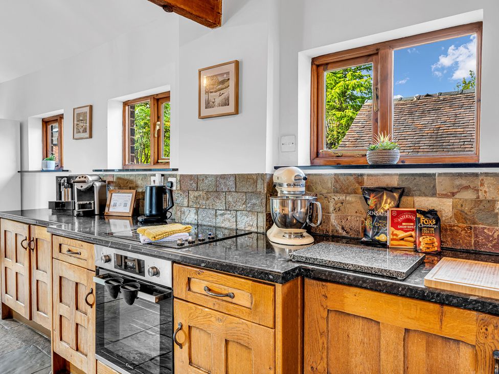 A kitchen with windows, coffee machine, kettle and mixer at Oxhay Barn Newcastle