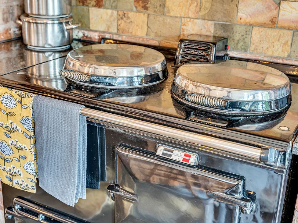 A stove with pots on top in the kitchen at Oxhay Barn Newcastle