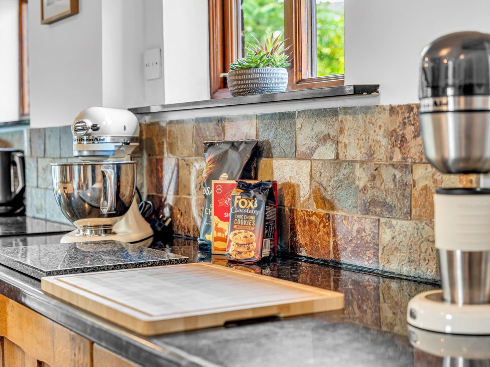 A kitchen with a mixer, kettle, and cookie packet at Oxhay Barn Newcastle