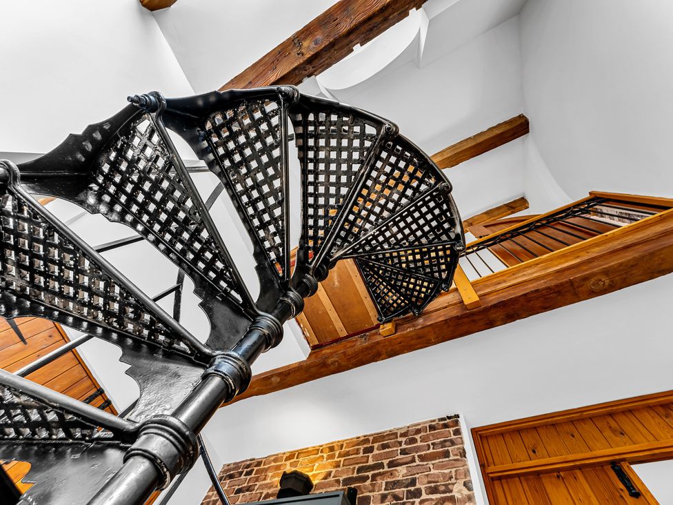 A spiral staircase with wooden beams at Oxhay Barn Newcastle