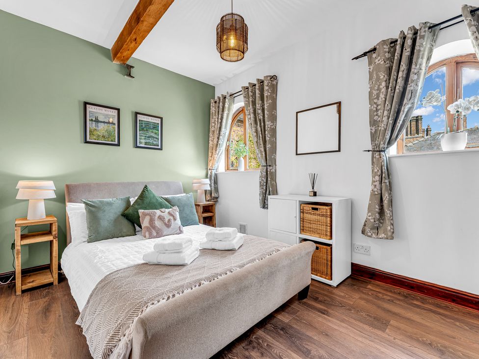 A bedroom with a bed, nightstand, and window at Oxhay Barn Newcastle