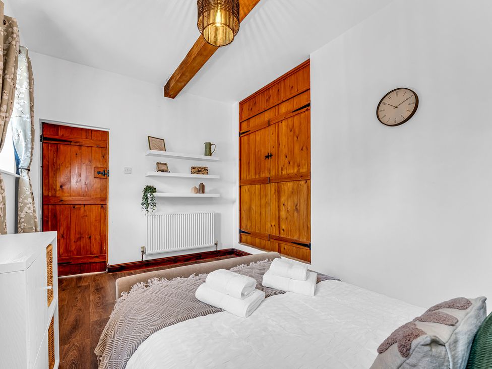 A bedroom with a bed and shelves at Oxhay Barn Newcastle