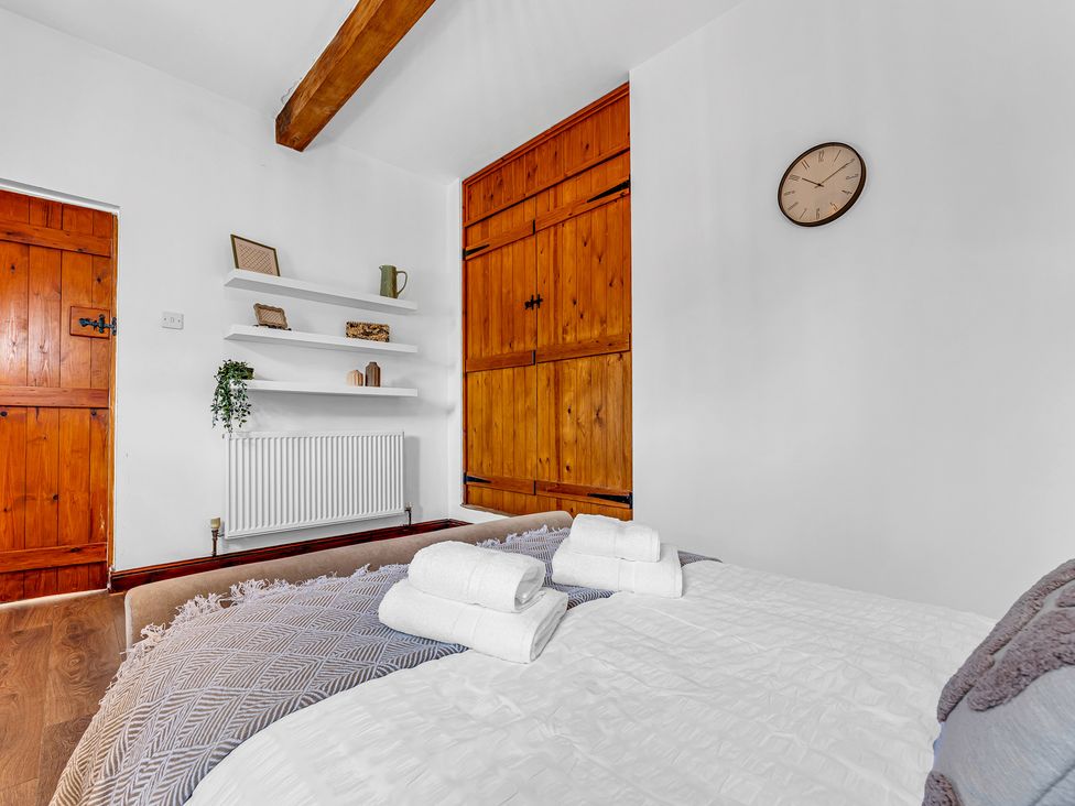 A bedroom with a bed and shelves at Oxhay Barn Newcastle